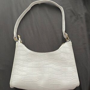 This is a small white purse that has plenty of room for your everyday belongings